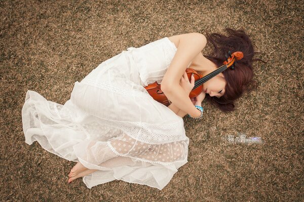 Beautiful girl in a wreath with a violin