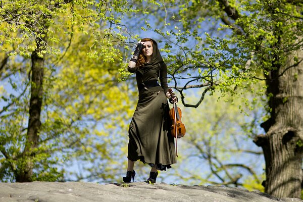 Dans la forêt musicale, la violoniste Hannah thiem pose dans une belle robe