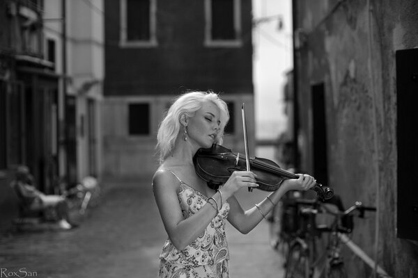 Dziewczyna gra na skrzypcach na ulicy