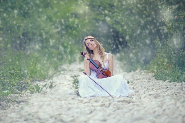 Photo of a violinist girl in nature