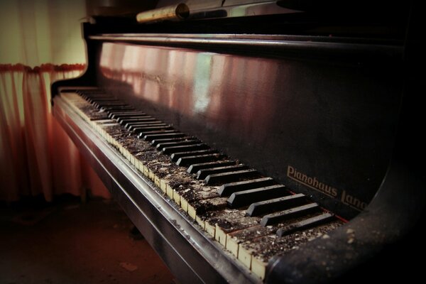 Una antigua casa abandonada tiene un piano de cola y un piano