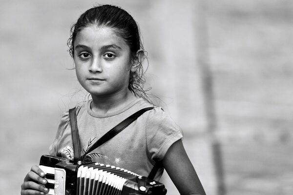 Photo en noir et blanc d une jeune fille avec un accordéon dans les mains