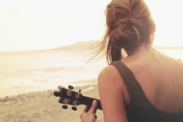 Chica tocando la guitarra en el lago