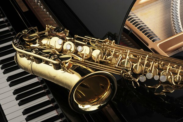 A shining saxophone is lying on the piano