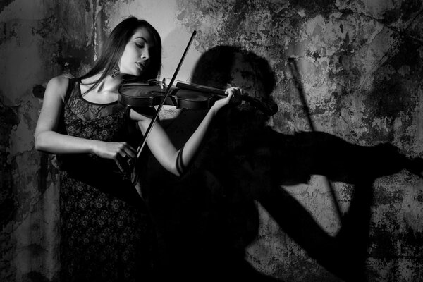 A girl plays the violin, a shadow falls