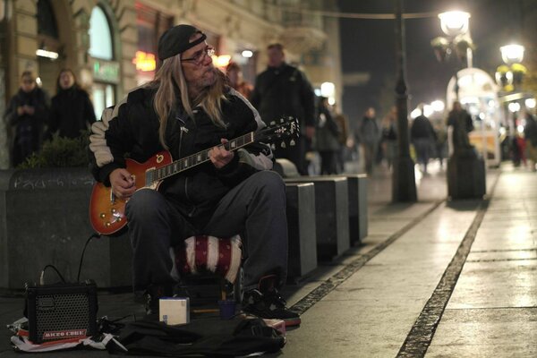 A street musician plays the guitar