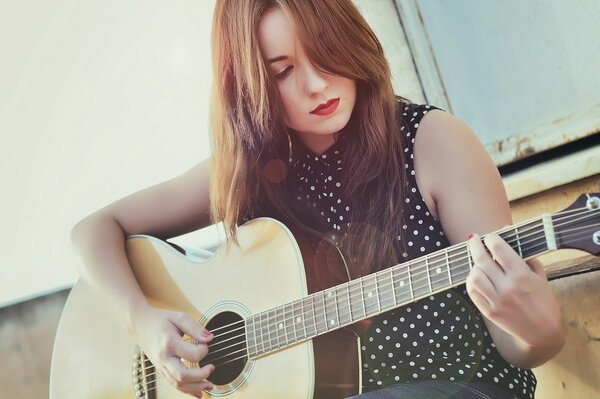 The girl composes music on the guitar