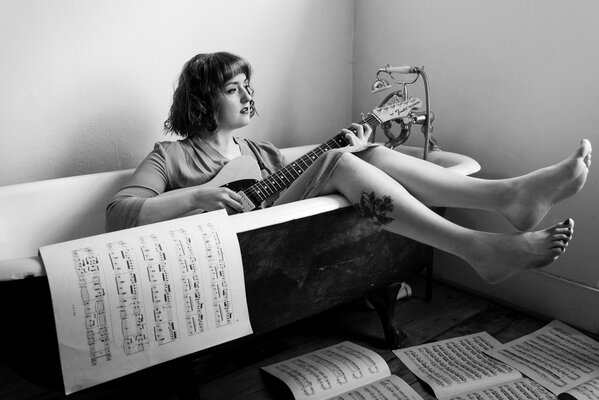 Mélancolie fille avec guitare dans la salle de bain