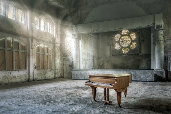 Antiguo piano de cola en la sala con vidrieras