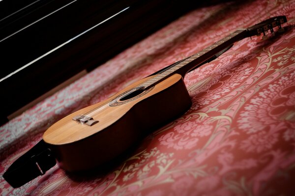 Guitarra contra una pared roja estampada