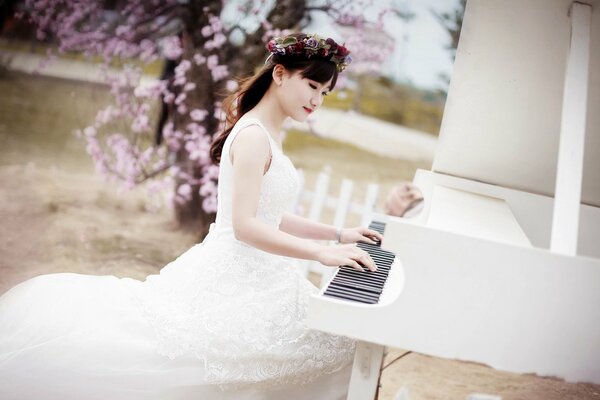 Chica asiática tocando música en el piano