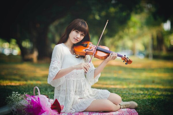 Oriental violinist in a dress with a violin