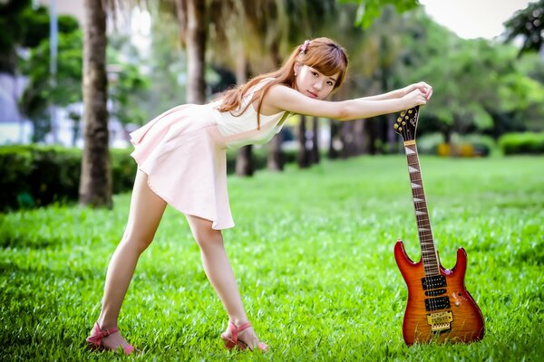 Girl with guitar summer on the grass