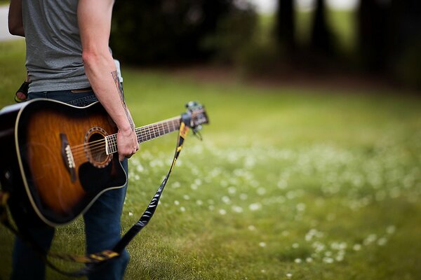 A guy in jeans with a guitar in his hand