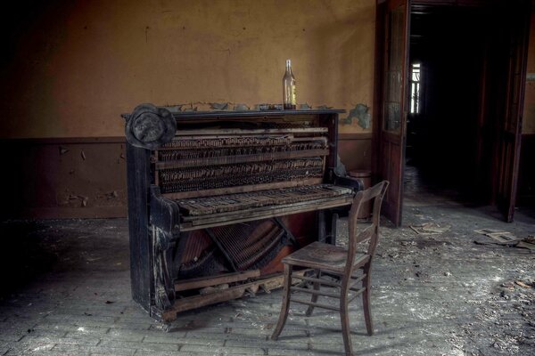 Bouteille sur un piano et une vieille chaise