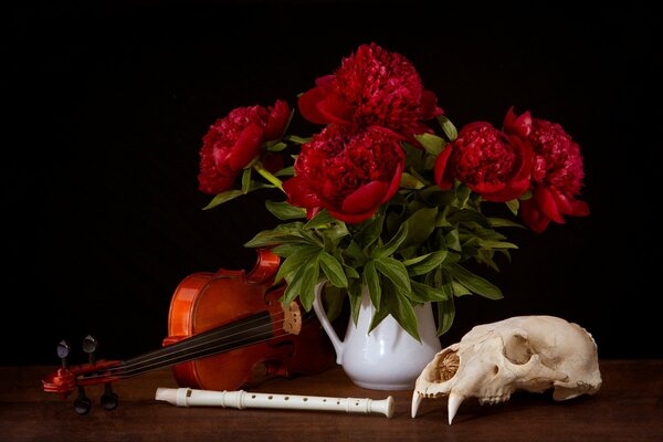 A vase with flowers and a violin with a skull