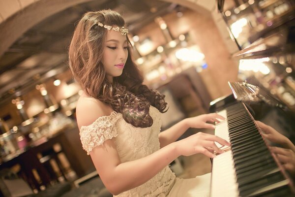 Chica tocando el piano en un vestido