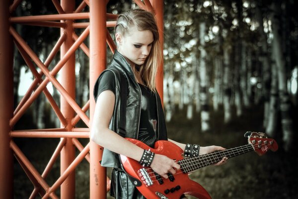 Rockero chica tocando la guitarra roja