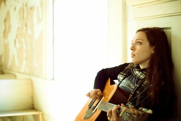 La cantante Carly Gibson se sienta con una guitarra