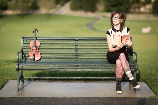 Chica sentada en un banco leyendo un libro