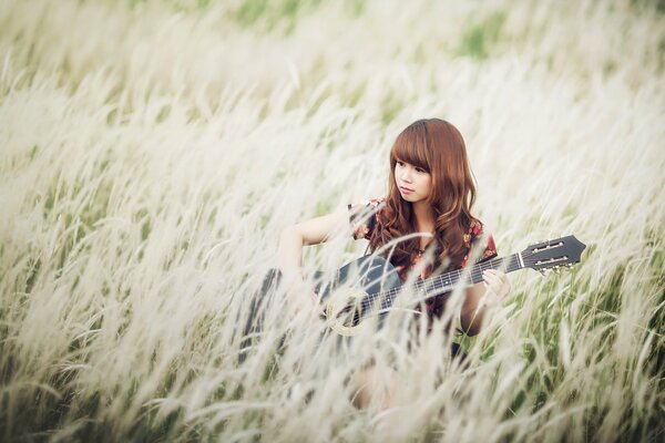 Mädchen mit Gitarre im Feld