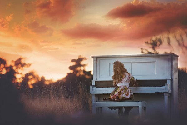 Ragazza che suona al tramonto al pianoforte