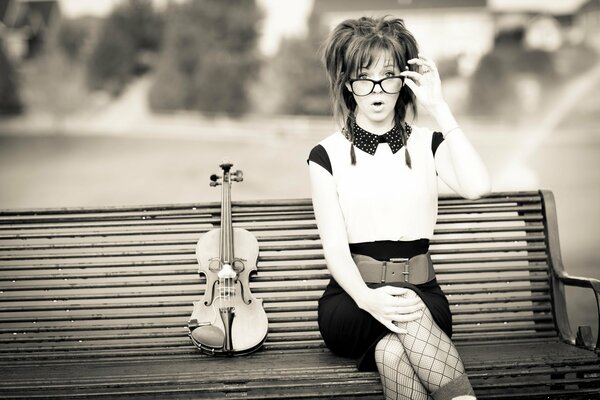 Lindsey Stirling su una panchina con un violino