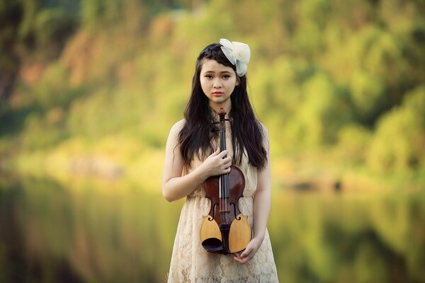 Fille avec violon dans la nature en été