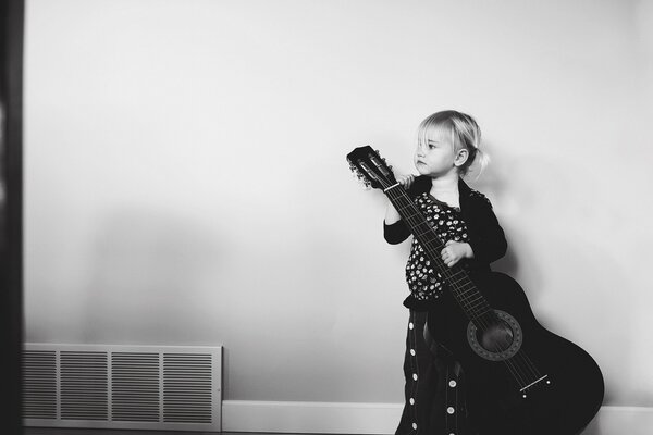 Petite fille avec une guitare noire