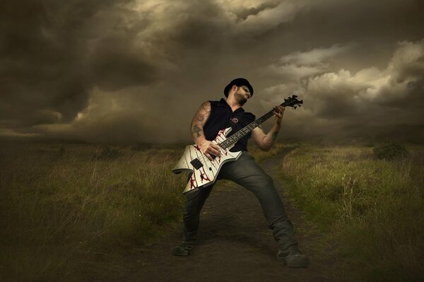 Rockmusiker mit Gitarre vor dem Hintergrund von Gewitterwolken