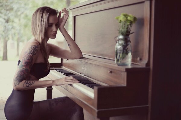 A girl plays the piano. Girl with a cigarette