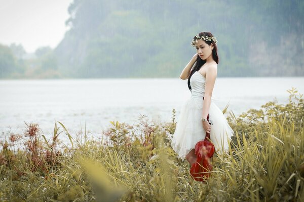 Asian girl on the river with a violin