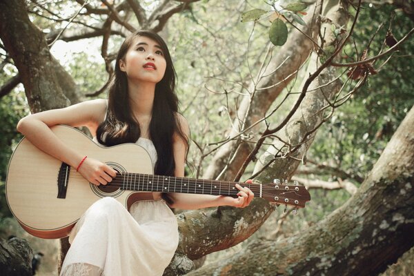 Asiatische Mädchen spielt Gitarre