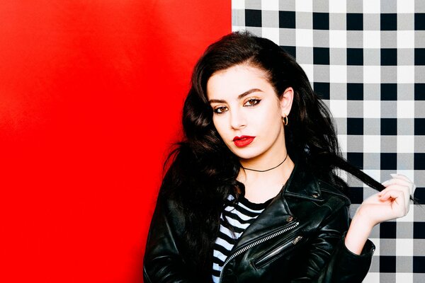 British singer Charlie XCX on a red and checkered background with red lips