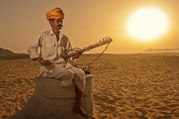 Un hombre de la India sostiene un instrumento musical