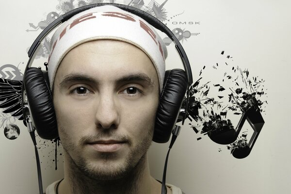A young man in black headphones listens to music