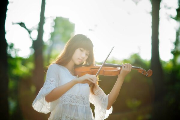 Chica asiática tocando música de violín