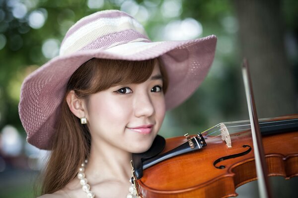 Mädchen mit Hut mit Geige spielt