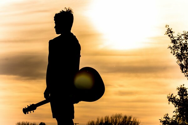 Dark silhouette of a man with a guitar