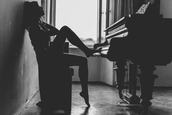 Ragazza nella foto in bianco e nero seduta al pianoforte