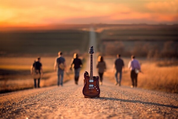 Шесть музыкантов уходят по дороге от гитары