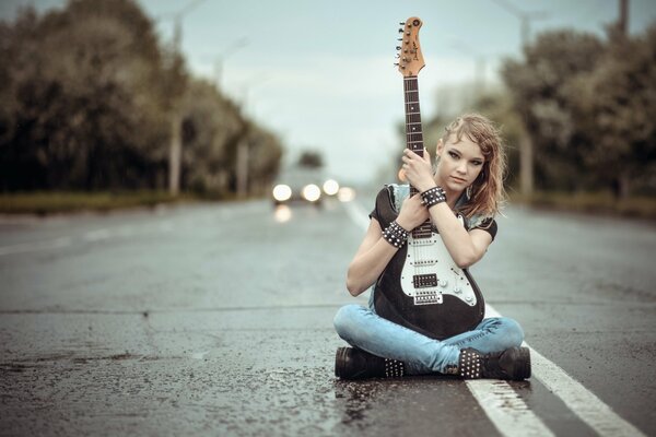 Девушка с гитарой посреди дороги