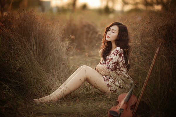 Ragazza asiatica con violino in natura