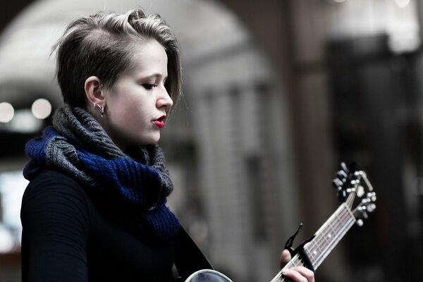 Ragazza con chitarra con acconciatura creativa