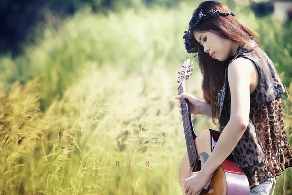 Fille sur le terrain joue de la guitare