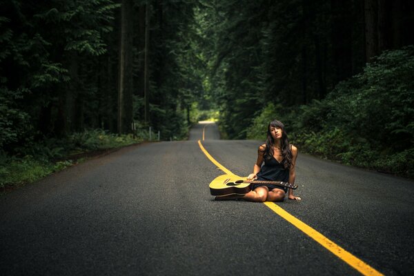 A girl with a guitar on the road