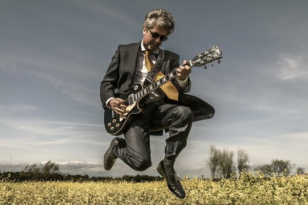 Homme avec une guitare dans un champ