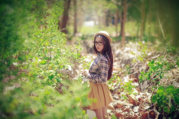 Chica con sombrero en el bosque en la primavera