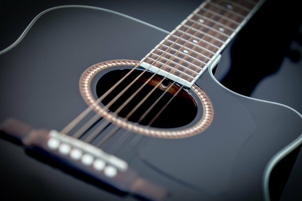 Macro photography of a black guitar on a dark background