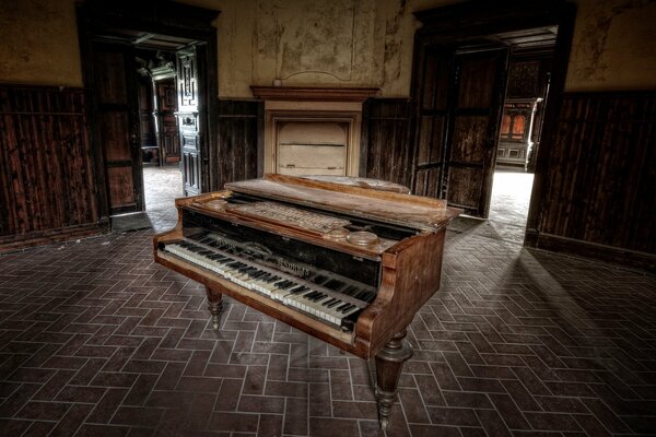 Vecchio pianoforte a coda nel mezzo di una casa abbandonata